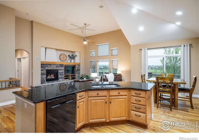 13943 W 87th Ln, Arvada, CO 80005 - kitchen with black dishwasher, a sink, light wood-style floors, open floor plan, and high vaulted ceiling