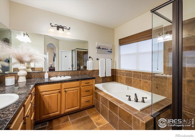 13943 W 87th Ln, Arvada, CO 80005 - bathroom featuring double vanity, a garden tub, a shower stall, and tile patterned flooring