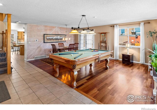 playroom with a textured ceiling, light tile patterned flooring, pool table, wood walls, and visible vents