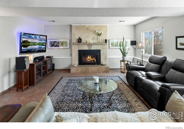 living area featuring a textured ceiling, a tile fireplace, visible vents, and tile patterned floors