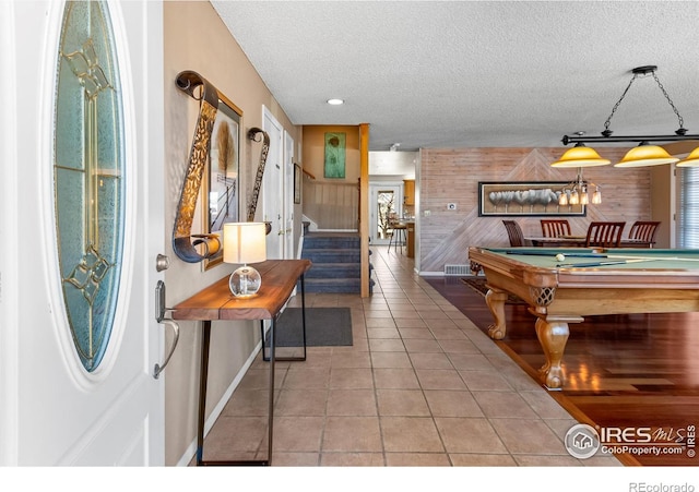 rec room with a textured ceiling, tile patterned flooring, wooden walls, billiards, and baseboards