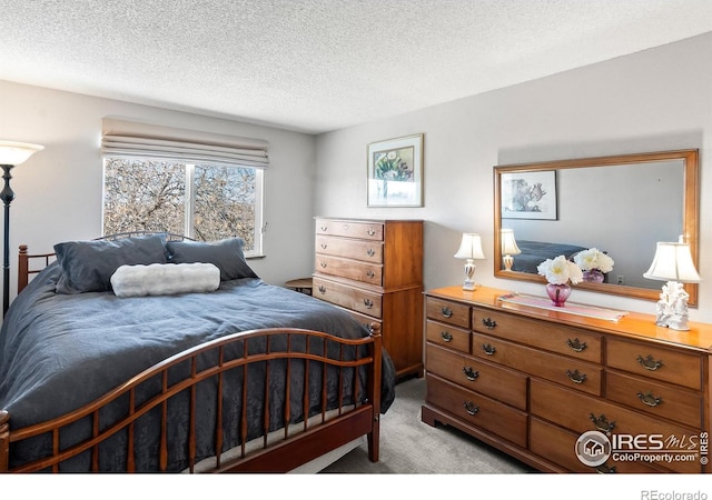 bedroom with light colored carpet and a textured ceiling