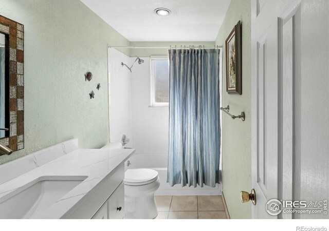 bathroom featuring a textured wall, vanity, toilet, and tile patterned floors