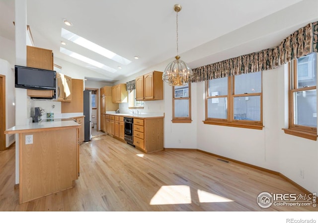 kitchen featuring wall oven, a peninsula, visible vents, light countertops, and freestanding refrigerator