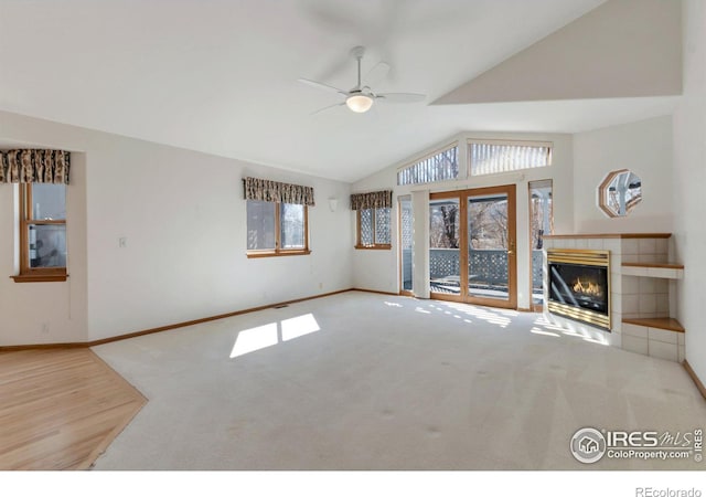 unfurnished living room featuring vaulted ceiling, carpet floors, a fireplace, and a ceiling fan