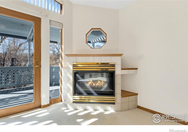 room details with a tile fireplace, carpet flooring, and baseboards