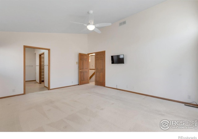 unfurnished bedroom with visible vents, ensuite bathroom, light carpet, high vaulted ceiling, and baseboards