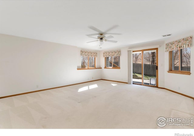 carpeted spare room with baseboards, visible vents, and a ceiling fan