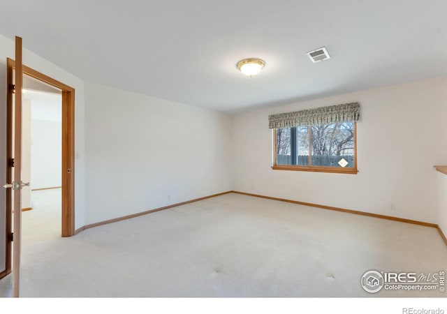 spare room featuring carpet, visible vents, and baseboards