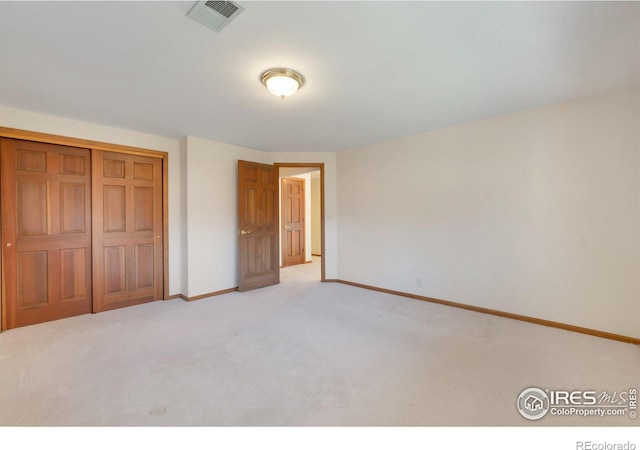 unfurnished bedroom with carpet flooring, a closet, visible vents, and baseboards