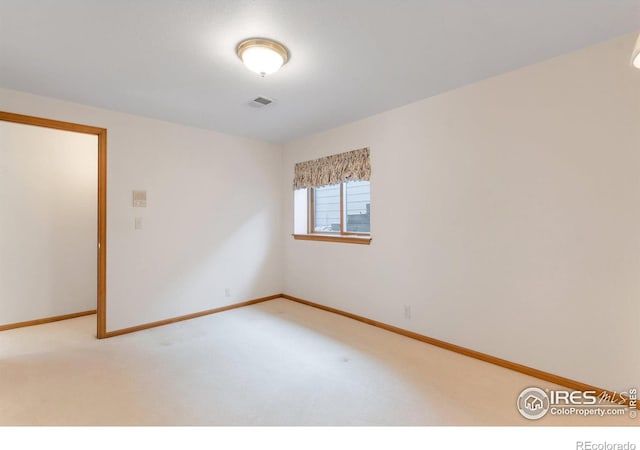 unfurnished room featuring carpet, visible vents, and baseboards