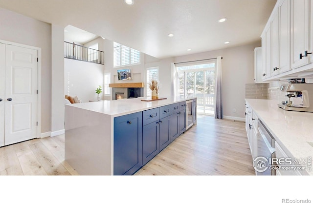 kitchen with dishwasher, light wood-style floors, white cabinetry, and decorative backsplash