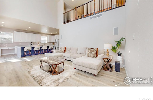 living area featuring light wood finished floors, recessed lighting, visible vents, and baseboards