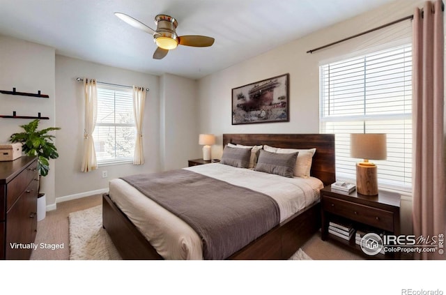 bedroom with a ceiling fan, baseboards, and carpet flooring