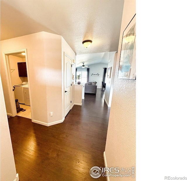 hallway featuring a textured ceiling, baseboards, and dark wood-type flooring