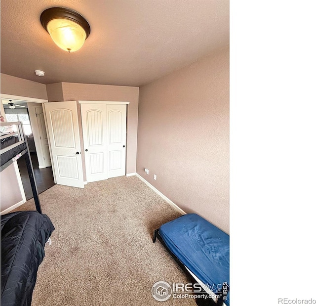 carpeted bedroom with a closet and baseboards