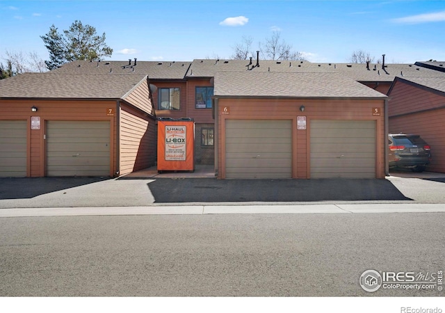 townhome / multi-family property with a garage and a shingled roof