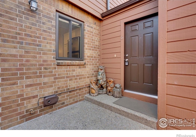 entrance to property featuring brick siding