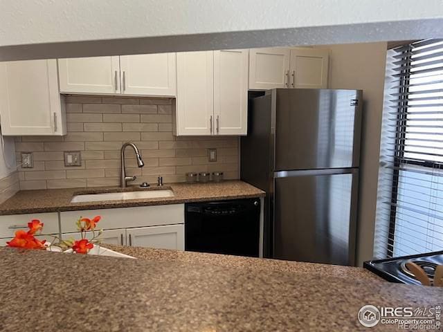 kitchen with freestanding refrigerator, white cabinets, a sink, and dishwasher