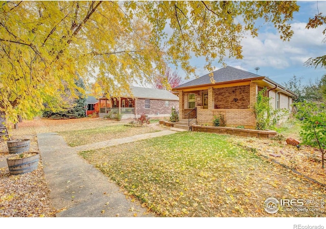 view of front of property featuring brick siding and a front yard