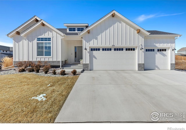 modern farmhouse with an attached garage, driveway, a shingled roof, and board and batten siding