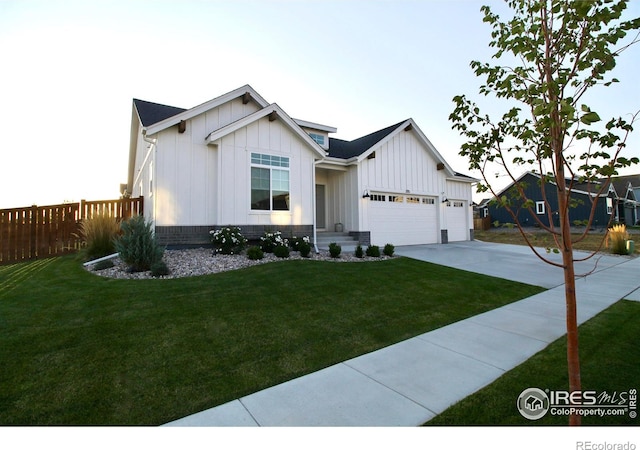 modern inspired farmhouse featuring an attached garage, board and batten siding, fence, driveway, and a front lawn