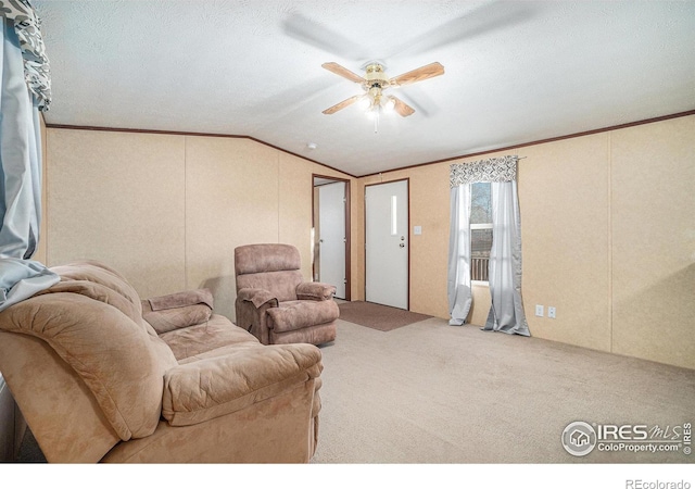 living room featuring a ceiling fan, vaulted ceiling, carpet flooring, and crown molding