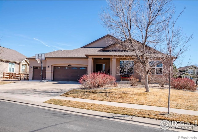 view of front of property featuring an attached garage, concrete driveway, and stucco siding