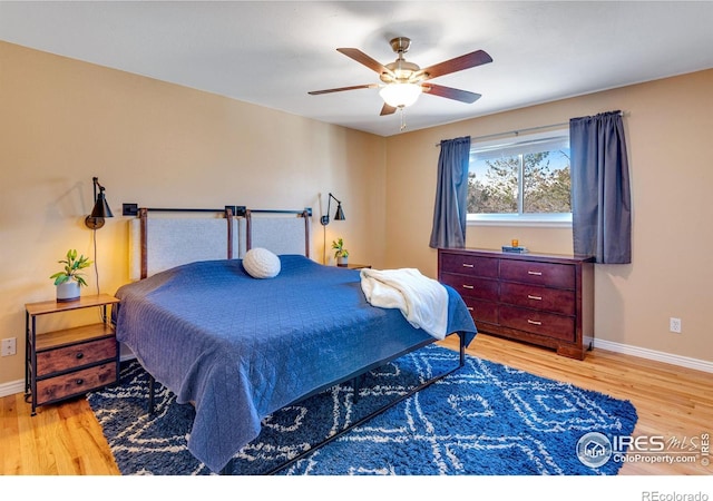 bedroom featuring wood finished floors, a ceiling fan, and baseboards