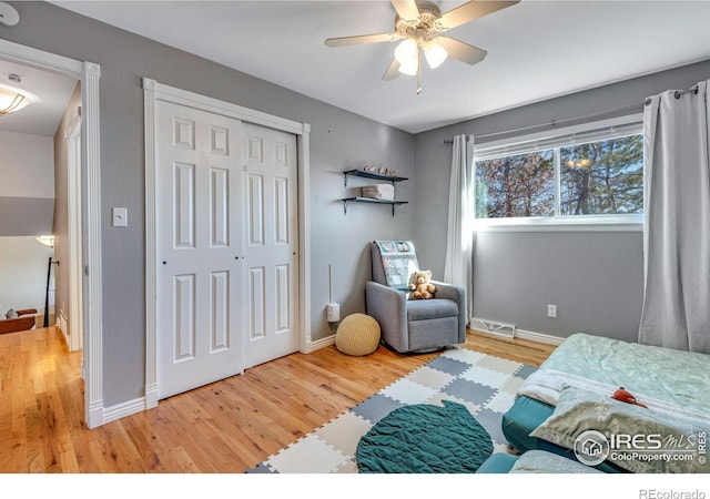 bedroom with baseboards, a closet, visible vents, and wood finished floors