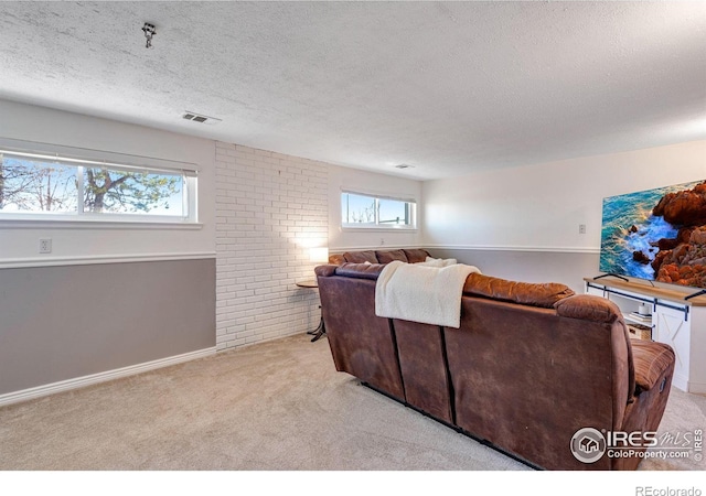 living room with light carpet, visible vents, and a textured ceiling