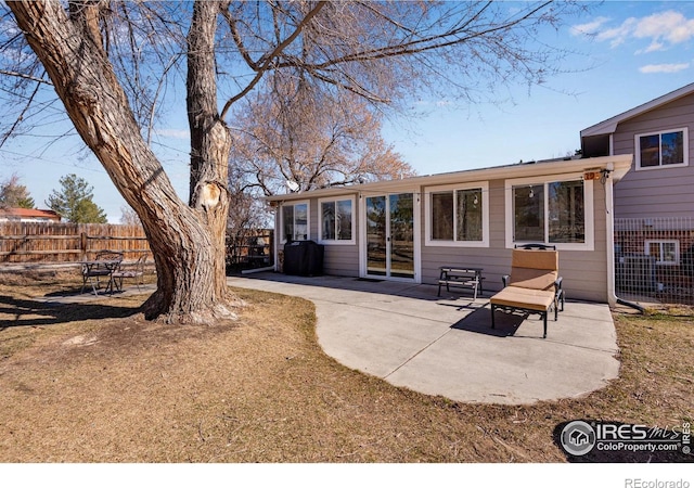 back of property featuring fence and a patio