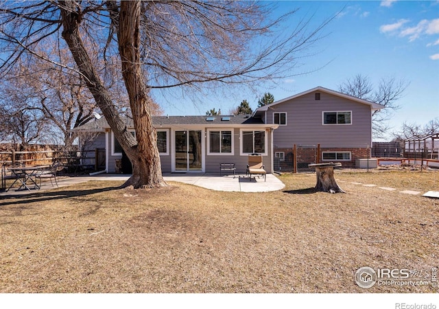 back of property with a patio area, fence, brick siding, and a lawn