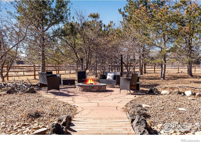 view of patio / terrace featuring fence and a fire pit