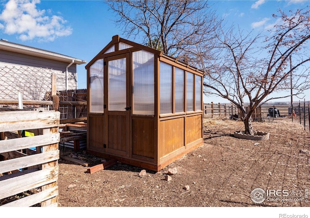 view of greenhouse with fence