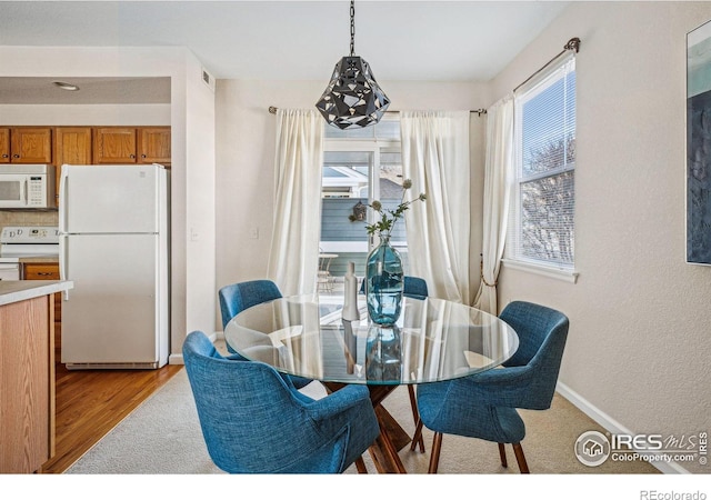 dining area featuring light wood-type flooring and baseboards