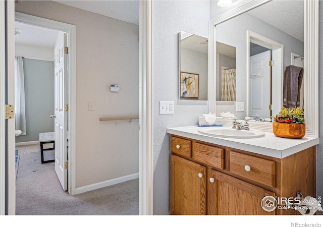 full bath featuring baseboards and vanity