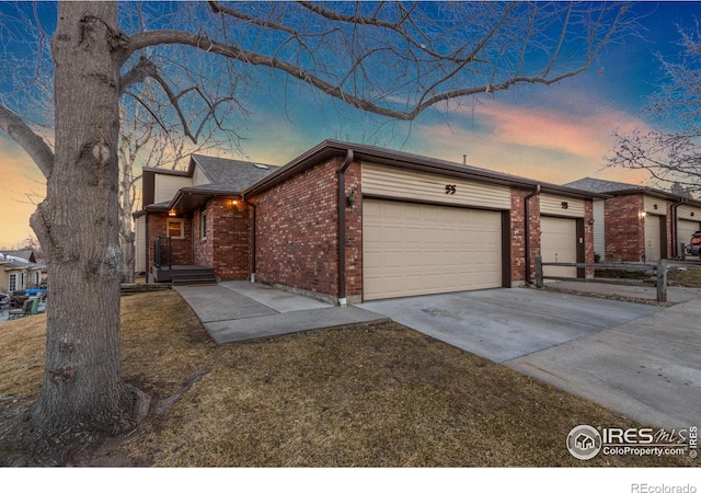 view of front of property with a garage, driveway, and brick siding