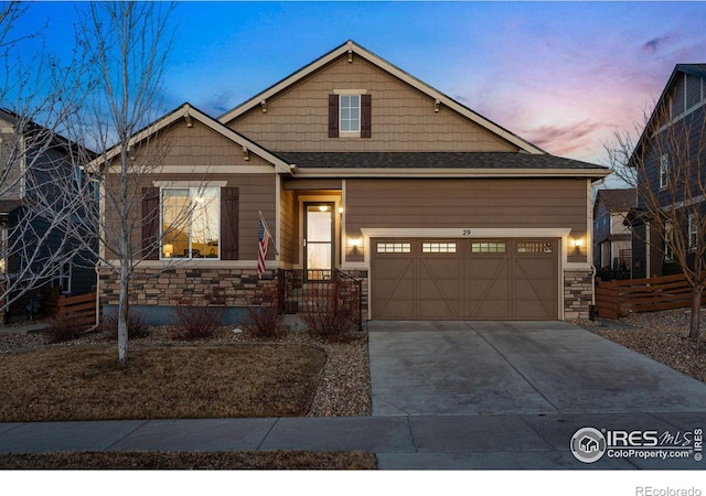 view of front of house featuring a garage, stone siding, and concrete driveway