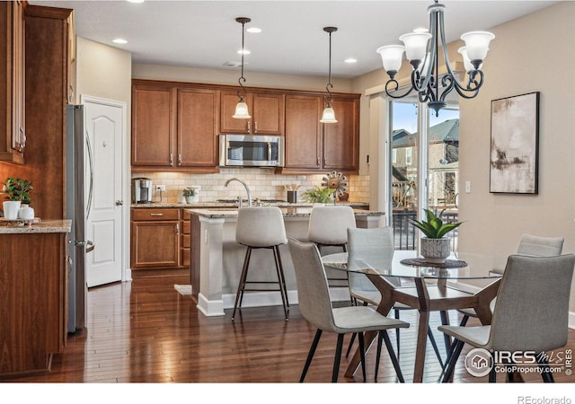 dining room featuring a chandelier, recessed lighting, and dark wood finished floors