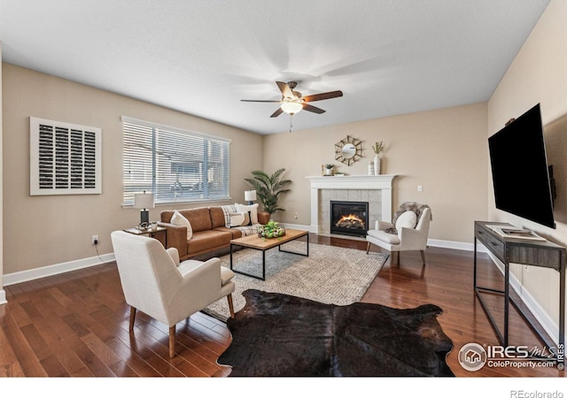 living room featuring baseboards, wood finished floors, and a tile fireplace