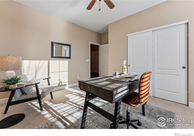 office with baseboards, ceiling fan, and light colored carpet