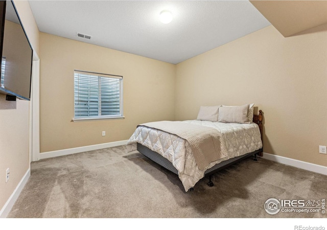 carpeted bedroom with visible vents and baseboards