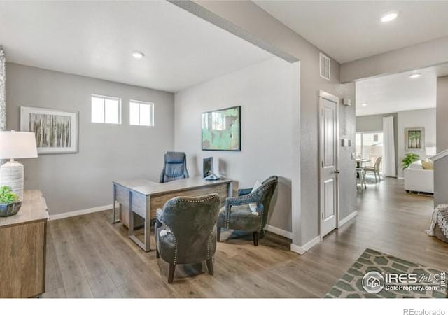 office with visible vents, plenty of natural light, baseboards, and wood finished floors