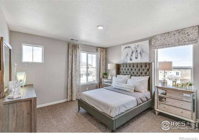 carpeted bedroom featuring multiple windows, visible vents, and baseboards