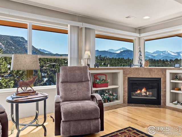 sitting room featuring visible vents, a fireplace, wood finished floors, and a mountain view