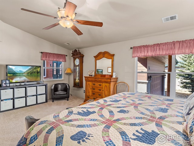 bedroom with lofted ceiling, carpet floors, visible vents, and a ceiling fan