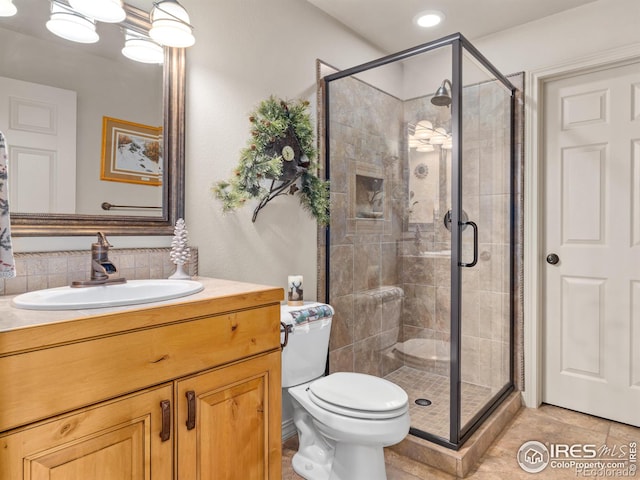 full bath featuring toilet, a stall shower, tile patterned floors, and vanity