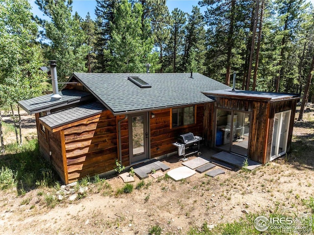 back of property featuring a shingled roof