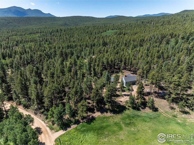 drone / aerial view with a forest view and a mountain view